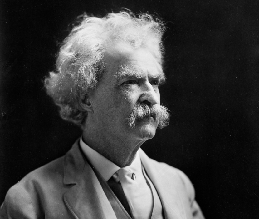 Black and White photograph from 1907 showing Mark Twain facing right, against a black background