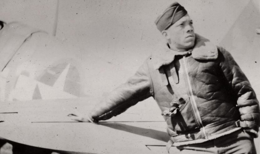 John Rogers Sr in uniform, leaning against an airplane