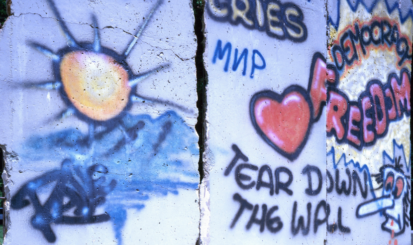 Photograph of section of Berlin Wall displayed at the Newseum museum in Virginia; Graffiti on the wall has messages including "Tear Down the Wall" and "Democracy Freedom"