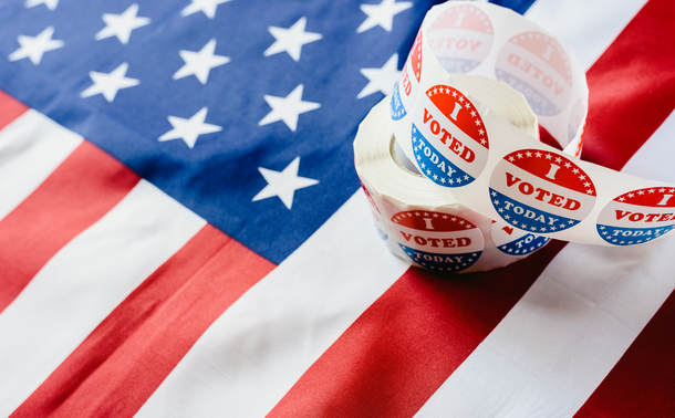 Roll of "I Voted Today" stickers resting atop an American flag