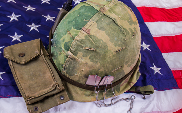 Soldier's helmet and dog tags laying on an American flag