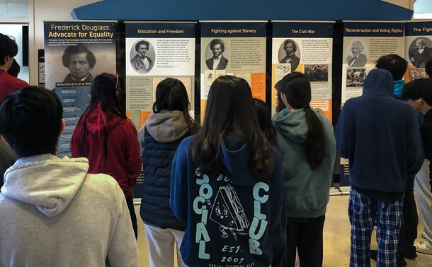 Students look at a historical traveling exhibition about the life of Frederick Douglass.