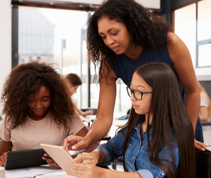 Photograph of Teacher helping two students