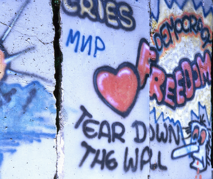 Photograph of section of Berlin Wall displayed at the Newseum museum in Virginia; Graffiti on the wall has messages including "Tear Down the Wall" and "Democracy Freedom"