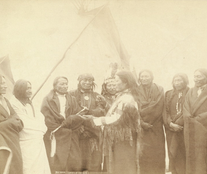 A group photograph of Lakota chiefs standing in front of tipi.