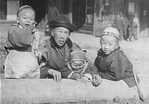 Photograph of one adult and three children in San Francisco's Chinatown