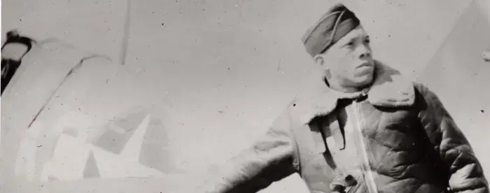 John Rogers Sr in uniform, leaning against an airplane