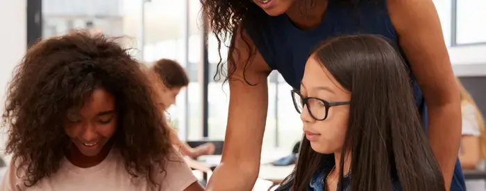 Photograph of Teacher helping two students