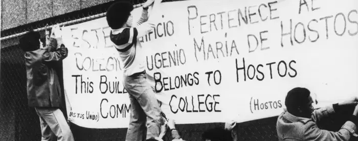 Student and faculty protestors hanging a banner at Hostos Community College