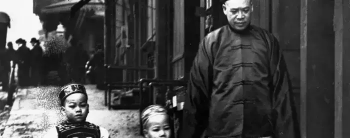 View of man and two children walking down street in the San Francisco Chinatown