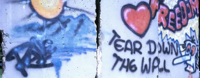 Photograph of section of Berlin Wall displayed at the Newseum museum in Virginia; Graffiti on the wall has messages including "Tear Down the Wall" and "Democracy Freedom"