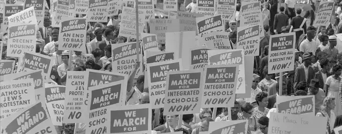 Black and white photograph showing the protest signs at the 1963 march on Washington, D.C. 