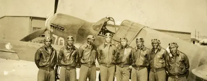 Group of WwII airmen posed by airplane at Tuskegee Army Airfield