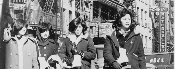 Four Chinese American girls carrying ice skates in Chinatown NYC