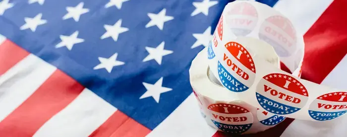 Roll of "I Voted Today" stickers resting atop an American flag