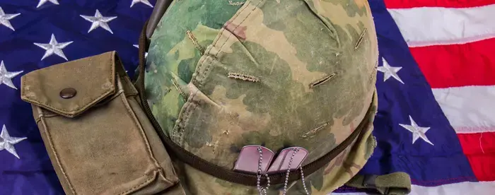 Soldier's helmet and dog tags laying on an American flag