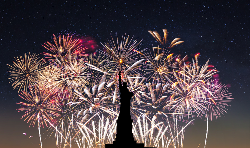 Fireworks in the background with silhouette of statue of liberty in foreground