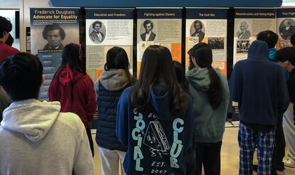 Students look at a historical traveling exhibition about the life of Frederick Douglass.