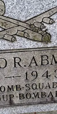 Color photograph of part of a headstone of Richard Abmeyer, featuring a graphic of a WWII bomber plane