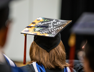 Student at the inaugural Gettysburg College-Gilder Lehrman MA graduation with cap saying 'Through it all she Mastered it'