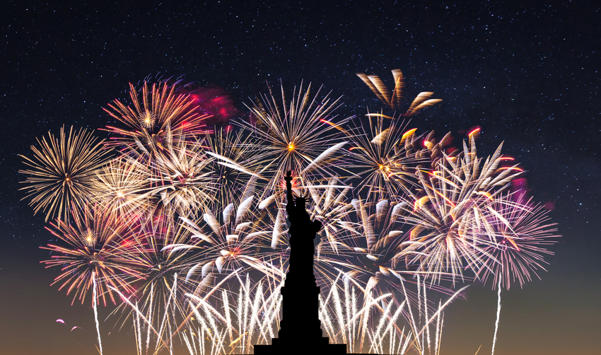 Fireworks in the background with silhouette of statue of liberty in foreground